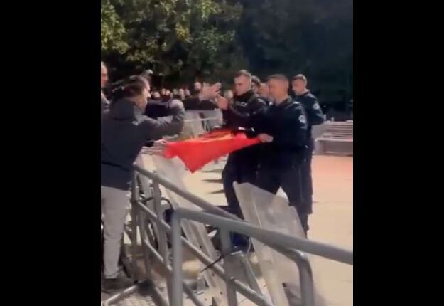 Protestuesit të gëzuar, ua dhurojnë flamurin e UÇK-së policëve
